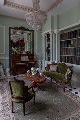 the chic expensive interior of the living room in the historical Baroque style, tiles on the floor, walls decorated with wood. the furniture is in a historical style.