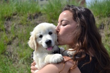 Young woman walking with her golden retriever puppy in her arms. Animal adoption. Life with a dog, with a golden retriever. Protect your pets. Man's best friend.