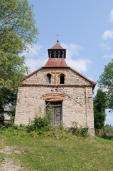 A Solitary Ruin: The Rustic Charm of an Abandoned Stone Chapel Bathed in Nature's Embrace