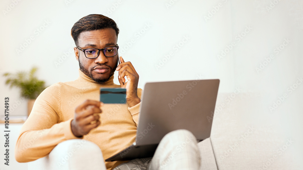 Poster online shopping problems. afro guy calling by phone using credit card and laptop sitting on sofa ind