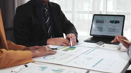 Business team collaborating and analyzing financial data while utilizing a digital tablet in a modern office setting