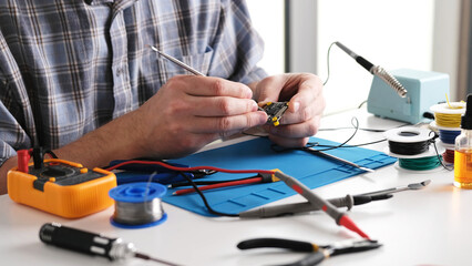 Master Checking Microchip Board In Repairs Workshop, Close Up View