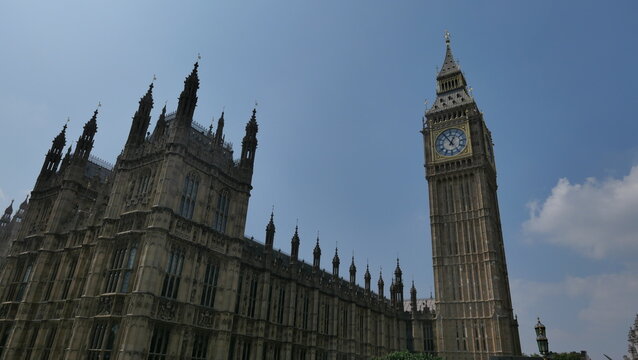 Sunny summer day in London, capturing the iconic Big Ben with clear skies. Showcasing the historic landmark's intricate architecture and its prominent place in the city's skyline.
