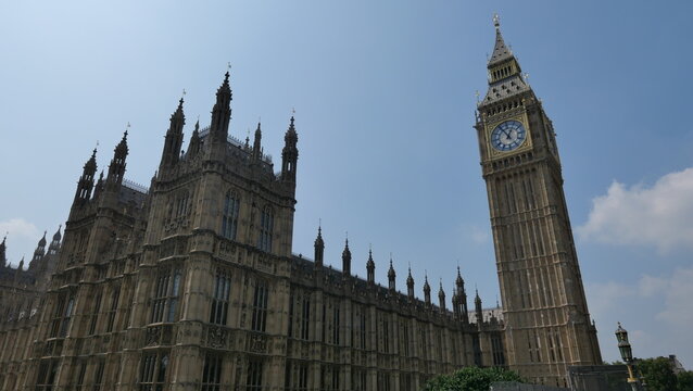Sunny summer day in London, capturing the iconic Big Ben with clear skies. Showcasing the historic landmark's intricate architecture and its prominent place in the city's skyline.