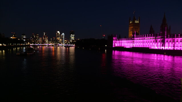 Night view of Big Ben in London, illuminated against the dark sky. Capturing the iconic clock tower's stunning architecture and its glowing presence in the city's evening skyline.