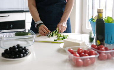 Woman'S Hands Are Slicing Cucumber For Greek Salad With A Glass Of White Wine Nearby