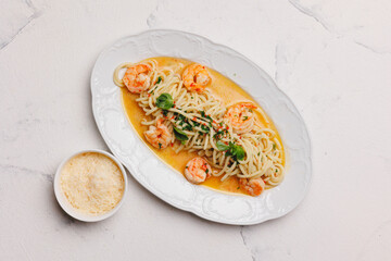 Spaghetti with seafood and cream sauce on a large white plate.