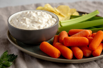 Homemade Carmelized Onion Dip with Baby Carrots, Chips and Celery, side view.