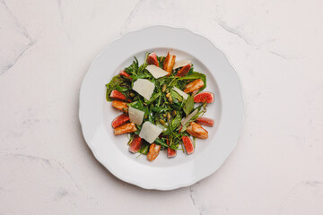 Hearty salad with shrimp and figs in a large white plate.
