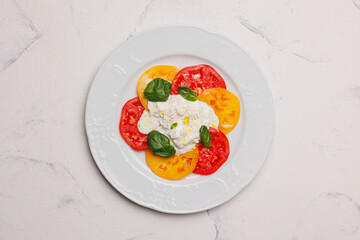 Thinly sliced ​​tomatoes with cheese and basil. Snack, aperitif.