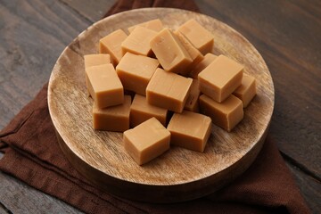 Tasty sweet caramel candies on wooden table, closeup