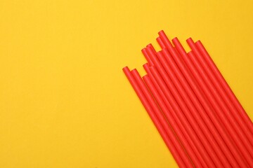 Bamboo drinking straws on yellow background, top view. Space for text