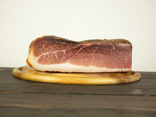 Whole speck on round wooden cutting board on the table