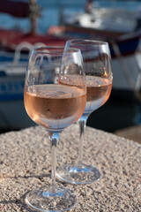 Glasses of cold rose Cote de Provence wine in old fisherman boats and yacht harbour in Saint-Tropez, summer vacation on French Riviera in Provence, France