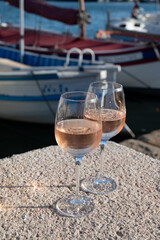 Glasses of cold rose Cote de Provence wine in old fisherman boats and yacht harbour in Saint-Tropez, summer vacation on French Riviera in Provence, France