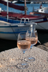 Glasses of cold rose Cote de Provence wine in old fisherman boats and yacht harbour in Saint-Tropez, summer vacation on French Riviera in Provence, France