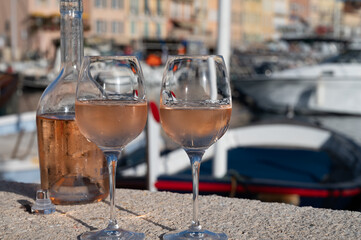 Glasses of cold rose Cote de Provence wine in old fisherman boats and yacht harbour in Saint-Tropez, summer vacation on French Riviera in Provence, France