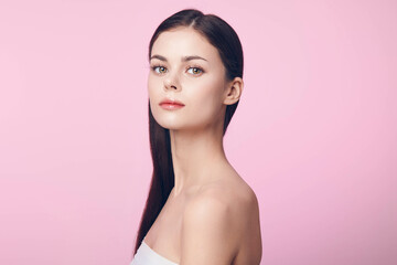 Portrait of beautiful young woman with long hair on pink background, isolated