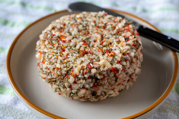 French cheese collection, fresh white soft goat cheese with aromatic herbs, garlic, parsley and red peppers close up