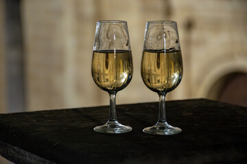 Sherry wine glasses with fino and old church on background at night in Jerez de la Frontera, wine glasses outdoor, cityview, Andalusia, Spain
