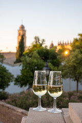 Sherry wine glasses and old bogedas jerez wine cellars and church on background in Jerez de la Frontera, wine glasses outdoor, cityview, Andalusia, Spain
