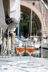 Party with rose wine on yacht boat anchored in port la Rague, Gulf of La Napoule, in Provence, two glasses of cold rose wine, French Riviera near Cannes, south of France