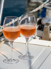 Party with rose wine on yacht boat anchored in port la Rague, Gulf of La Napoule, in Provence, two glasses of cold rose wine, French Riviera near Cannes, south of France