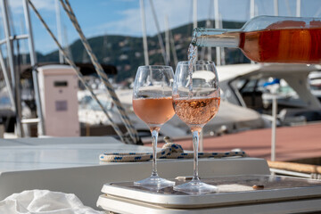 Party with rose wine on yacht boat anchored in port la Rague, Gulf of La Napoule, in Provence, two glasses of cold rose wine, French Riviera near Cannes, south of France
