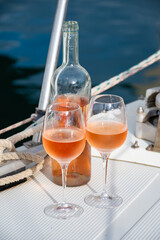 Party with rose wine on yacht boat anchored in port la Rague, Gulf of La Napoule, in Provence, two glasses of cold rose wine, French Riviera near Cannes, south of France