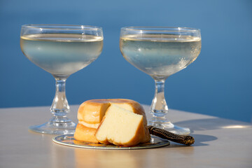 Sweet italian dessert ricotta cheese baked with lemon and glasses of Prosecco sparkling wine served on Ligurian coast with view on sea, summer in Italy