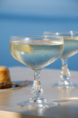 Cold sparkling wine, cava or champagne in two coupe glasses on table with blue sea water view, French Riviera is summer, France