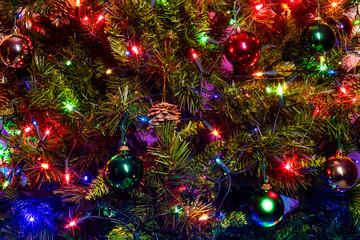 Close-Up of Decorated Christmas Tree with Red, Green, and Gold Ornaments, Pine Cones, and Colorful...