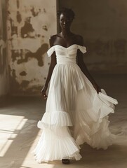 Fototapeta premium Elegant dark-skinned model in an off-the-shoulder white bridal gown, layered and flowing fabric, standing confidently in a sunlit room with worn walls, soft shadows highlighting the scene’s rustic ele