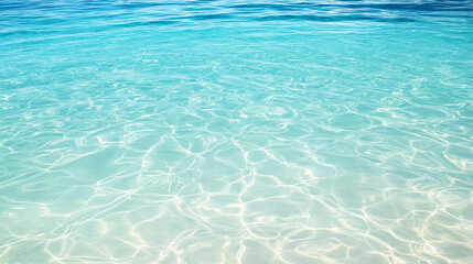 Obraz premium Crystal clear turquoise water with sunlight reflections on the ocean floor, creating a peaceful and serene background, perfect for beach and summer-themed designs.