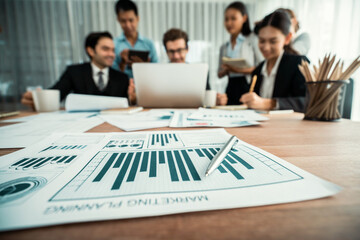 Piles of analyzed financial data dashboard on meeting table with background of business people...