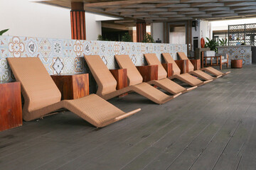 Brown lounge chairs or sun loungers made from rattan which are usually used in pools, swimming pools or spas.