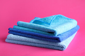 Stack of blue microfiber cloths on pink background
