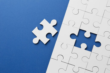 White puzzle pieces on blue background, top view