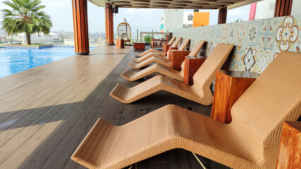 Brown lounge chairs or sun loungers made from rattan which are usually used in pools, swimming pools or spas.