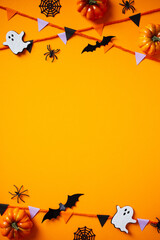 Halloween composition with cute bats, ghosts, pumpkins, spiders, bunting flag garland on orange...