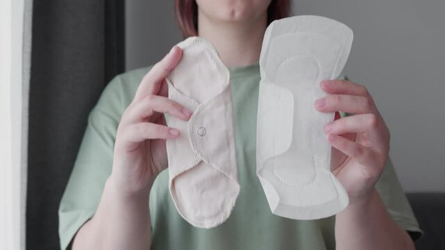 woman hands holding Reusable textile pad and disposable pad making decision of hygienic products. Different types of feminine menstrual hygiene materials 