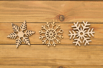 Beautiful snowflake on woden background, top view