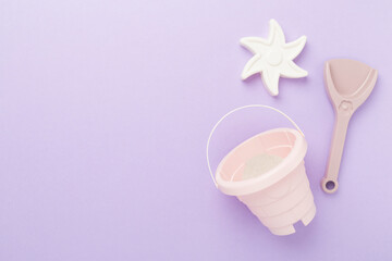 Cute toys for playing with sand on color background, top view