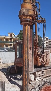 Hydraulic drilling rig for Installing a bored piles with a casing string on a construction site. Construction of drilled piles for a buried tunnel bulkhead
