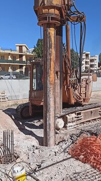 Hydraulic drilling rig for Installing a bored piles with a casing string on a construction site. Construction of drilled piles for a buried tunnel bulkhead