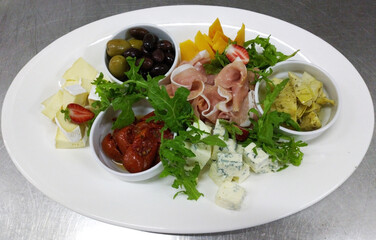 antipasto - a delicious appetizer with wine: black olives, elite varieties of cheese, jamon and prosciutto. healthy and nutritious food. great appetizer for an aperitif