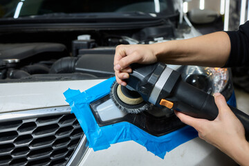 Person using a machine to polish automotive lighting on a car headlight