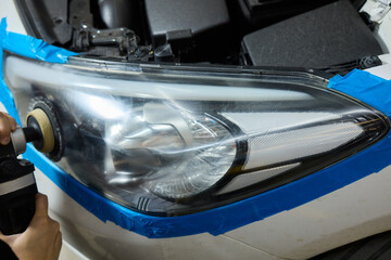 Person using a machine to polish automotive lighting on a car headlight