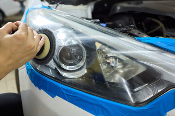 Person using a machine to polish automotive lighting on a car headlight