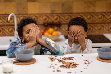 Siblings sitting at the table and refusing food looking unhappy